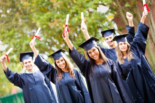 Happy group of students with arms up at their graduation.jpeg